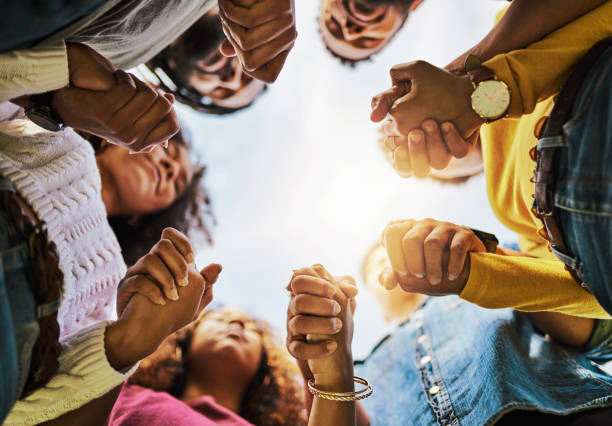 young people holding hands in a circle