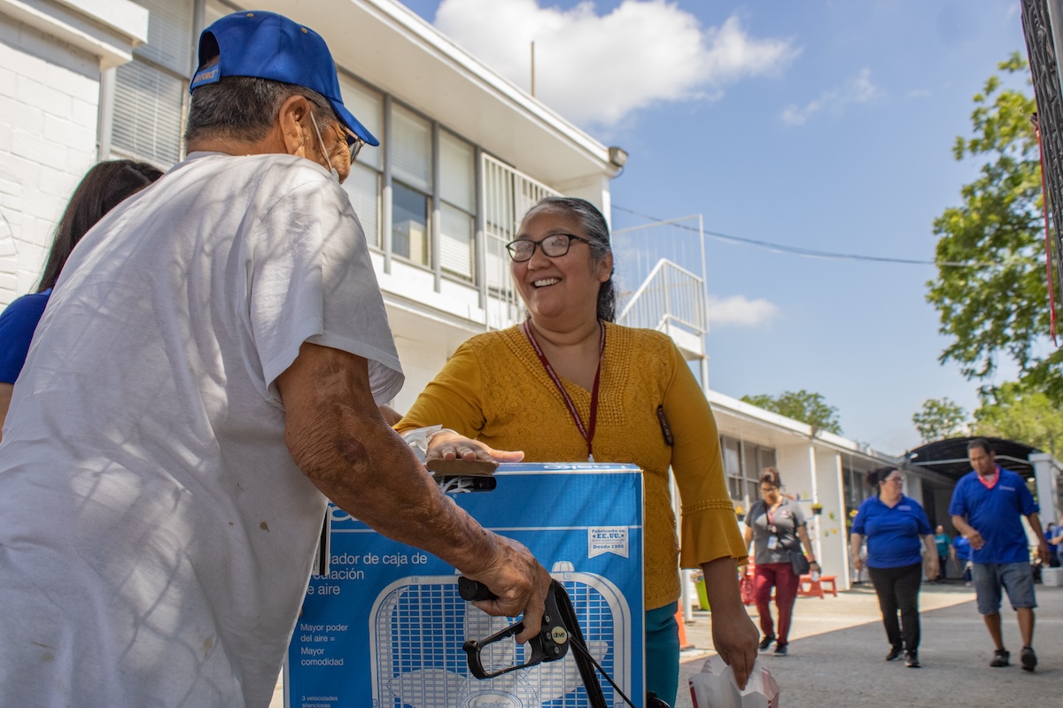 a lady providing a fan to a man in the community