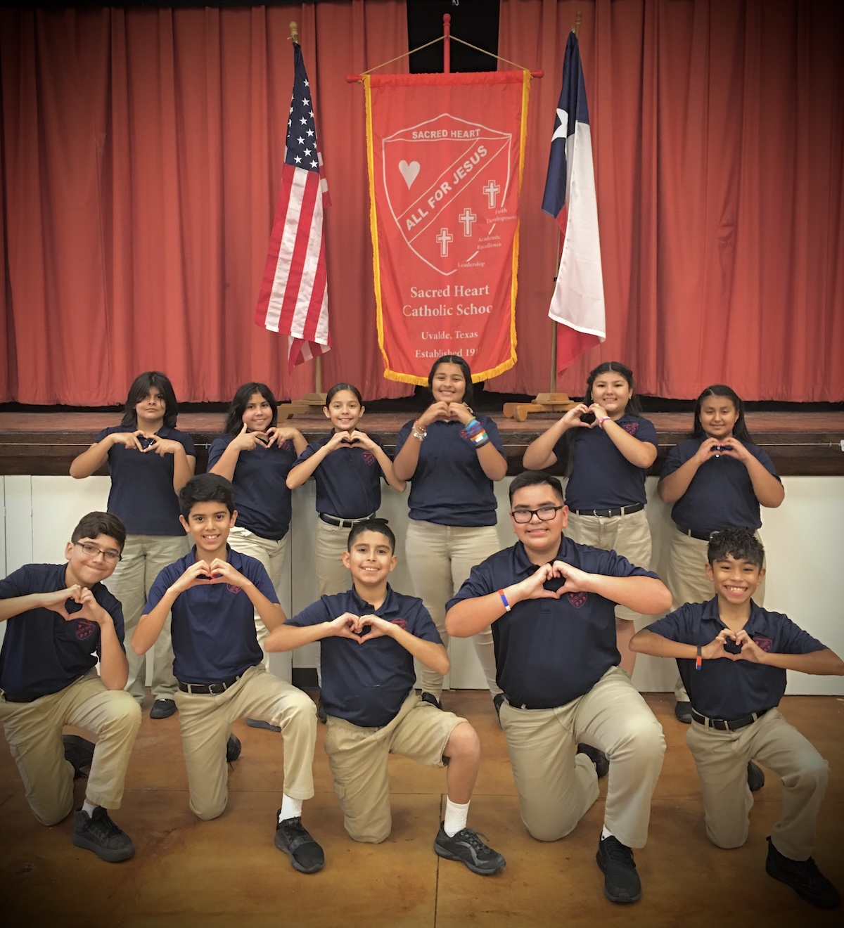 school class smiling and making a heart sign