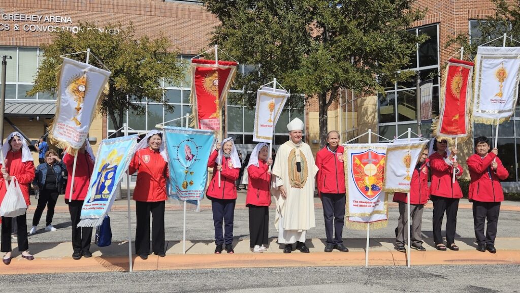 Archbishop Gustavo García-Siller standing on sidewalk with parishioners