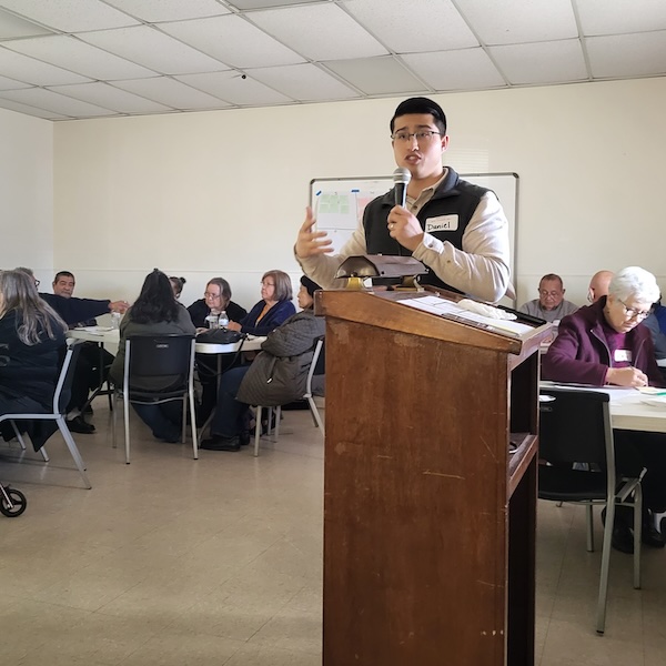 man speaking to a group of people