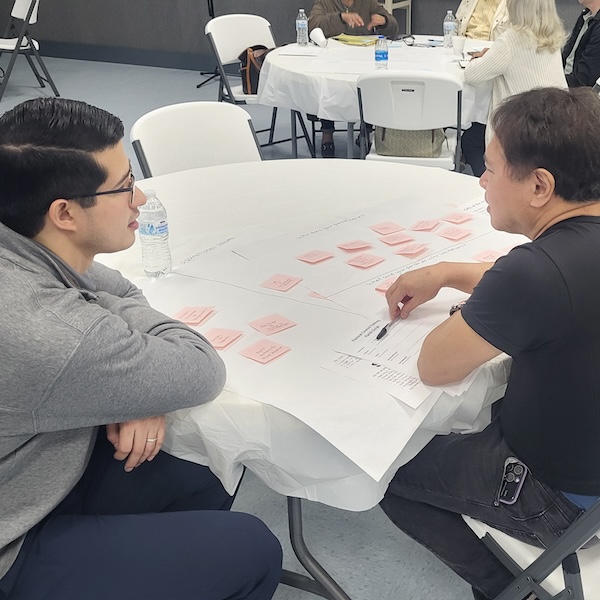 two men sitting at a table talking