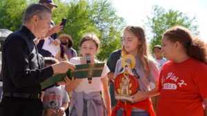 A girl speaking into a microphone at Care for Creation outdoor Mass