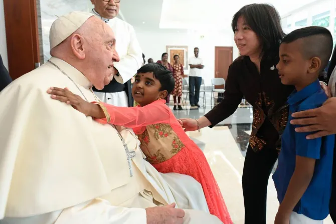 Pope Francis greets an orphan