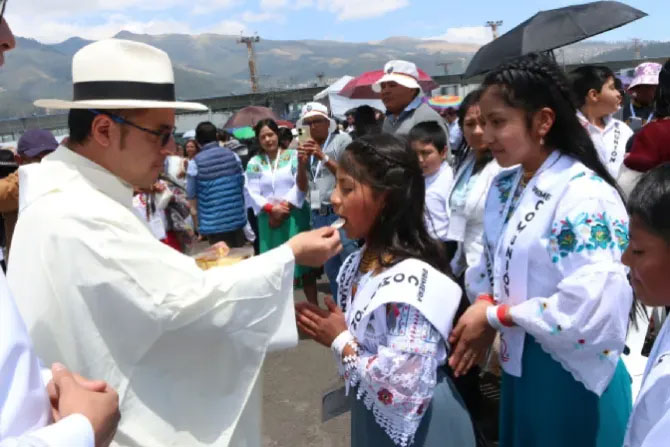 A priest gives Communion to children at the 53rd International Eucharistic Congress in Quito, Ecuador