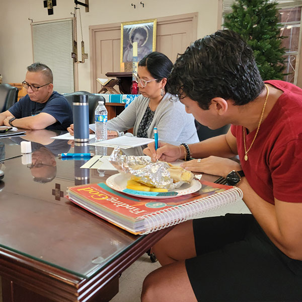 People discerning a plan while sitting around a table