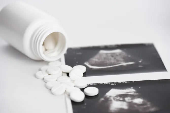 Bottle of pills spilling out over ultrasound images