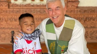 Father “Kike” Figaredo with one of the disabled children he helps in Cambodia