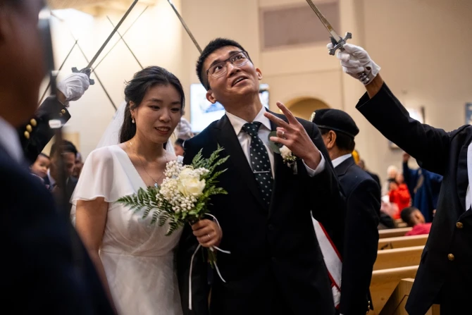 A groom flashes a peace sign at wedding-goers while processing out of St. Mary’s Church in Vancouver, British Columbia, Canada